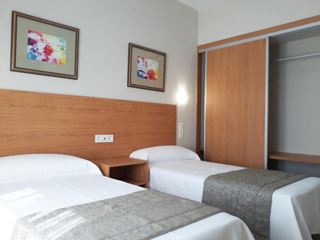 Twin Room at Hostal Montemayor with two single beds and wooden headboard