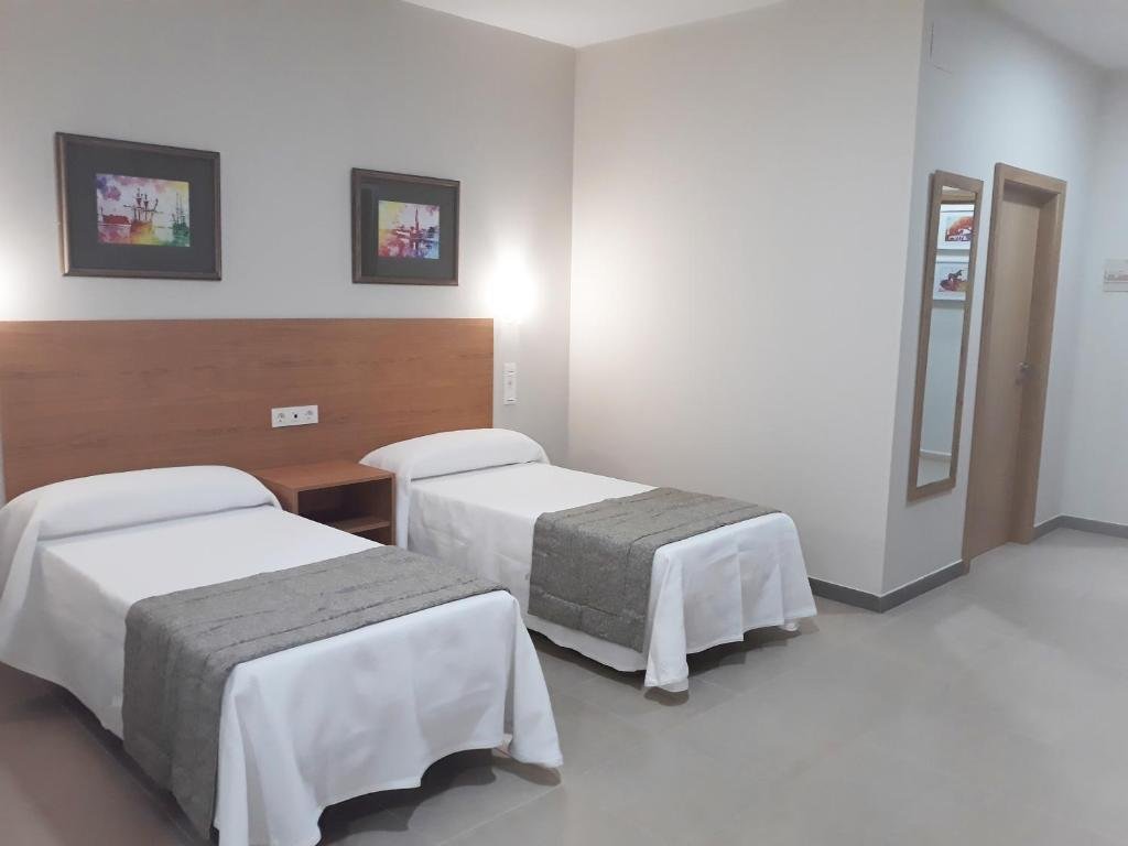 Single Room at Hostal Montemayor with a single bed and framed artwork